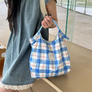 Vue détaillée du sac à main en tissu à carreaux bleus, style doux, sac de transport léger.