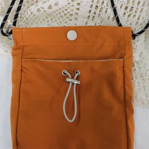 Oranger kleine Umhängetasche aus Nylon für Handy, Freizeitzubehör Detailansicht mit Kordel.