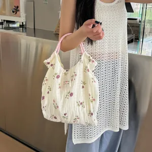 Détail sac à main en tissu floral, joli imprimé floral, anses roses, sac bandoulière.