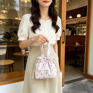 Close-up detail of the cute pink corduroy drawstring handbag with delicate pattern and handle.