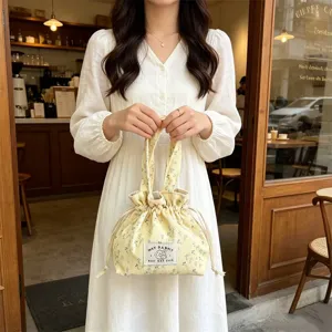 Floral corduroy drawstring bento bag detail shot, cute yellow portable handbag style.