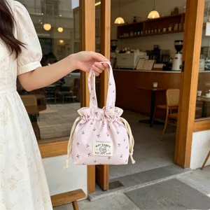 Pink floral corduroy drawstring handbag detail, cute portable bento storage bag lifestyle shot