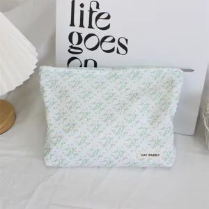 Corduroy floral cosmetic bag with zipper and label, portable makeup pouch for daily use.