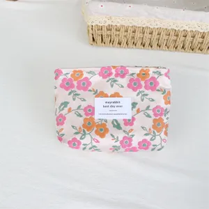 Close-up detail of the retro floral cosmetic pouch featuring jacquard fabric and sewn label.