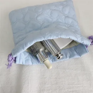 Pochette cordon motif cœur matelassé bleu clair détail, sac de rangement en coton pour maquillage.