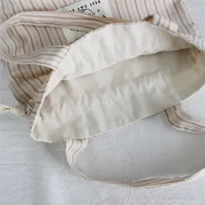 Détail de sac cabas cordon en toile rayée, jolie poche en tissu avec poignées usage quotidien.