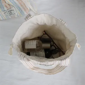 Vue de détail intérieure du sac cordon en toile rayée montrant sa grande capacité.