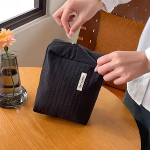 Detailansicht der schwarzen strukturierten Kosmetiktasche mit praktischem Reißverschluss.