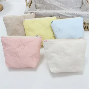 Cute quilted cosmetic bag with bow motif, portable mini zipper storage pouch for daily use.