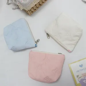 Small quilted makeup pouch with cute bow embossed pattern, portable zipper storage bag.