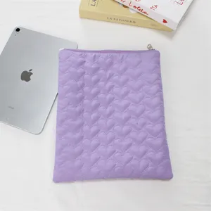 Detailed close-up of the cute purple quilted heart tablet sleeve and soft inner bag texture.