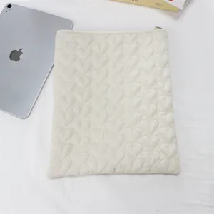 Quilted heart pattern tablet sleeve detail, soft beige padded pouch for daily protection.