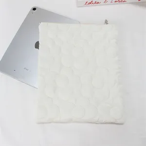 White quilted tablet sleeve with flower stitching design, soft padded laptop storage bag.