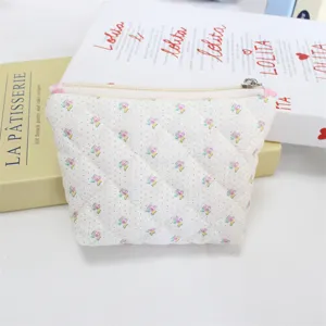 Close-up of quilted cosmetic pouch with floral pattern, cute zipper storage bag detail shot