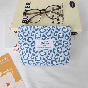Détail de la trousse de maquillage léopard bleu, pochette cosmétique rétro, sac de rangement.