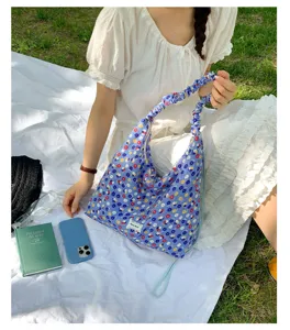 Detail view of a stylish floral shoulder bag with a cute scrunchie strap and blue print.