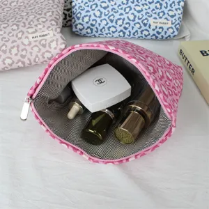 Vue détaillée de la trousse de maquillage chic à imprimé léopard avec doublure intérieure spacieuse.