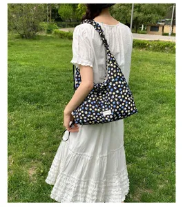 Floral shoulder bag detail view, casual black hobo bag with blue and yellow small flowers.