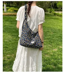 Detailed outdoor view of black floral hobo shoulder bag with gathered strap, casual style.