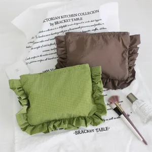 Detailansicht süßer Nylon-Karokosmetiktaschen mit Rüschenkanten für stilvolle Aufbewahrung.