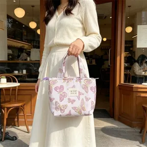 Detail view of the vintage butterfly print canvas bento handbag in elegant light purple color.