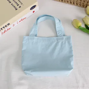 Light blue mini nylon tote bag detail view, casual solid color handbag for daily use.