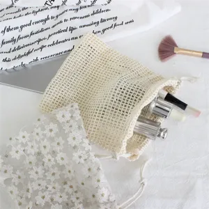 Mesh drawstring storage bag for cosmetics and jewelry, portable lace makeup pouch organizer.