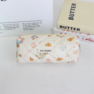 Vue rapprochée de la trousse matelassée avec motif d'ours mignon en blanc crème.