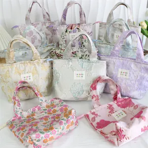 Detail view of ins style vintage embossed jacquard handbag, elegant floral print lunch tote bag.