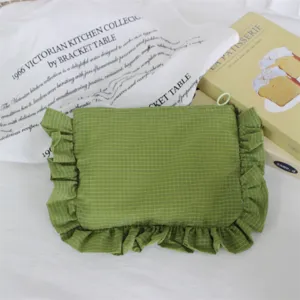 Detailansicht der grünen karierten Kosmetiktasche mit Rüschen, wasserdichtes Nylonmaterial.