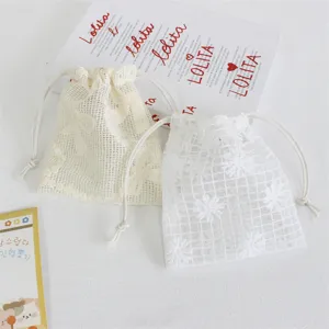 Detail shot of mesh drawstring bags with floral and daisy embroidery for gift and jewelry storage.