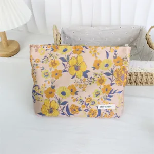 Detailed close-up of retro floral jacquard cosmetic pouch, elegant pink fabric with yellow flowers.