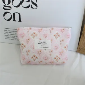 Detailed close-up of a pink corduroy floral makeup bag with a cute label for daily use.