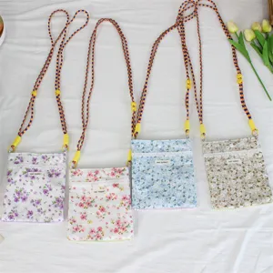 Blumiges Mini-Umhängetasche Detail mit bunten geflochtenen Riemen und zarter Paspel.