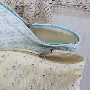 Close-up detail of cute floral corduroy makeup bag with smooth zipper, aesthetic storage.