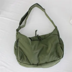 Dettaglio borsa a spalla in nylon verde, design casual con tracolla regolabile.