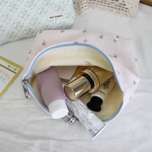 Corduroy cosmetic bag interior detail showing large capacity, cute bow pattern and zipper.
