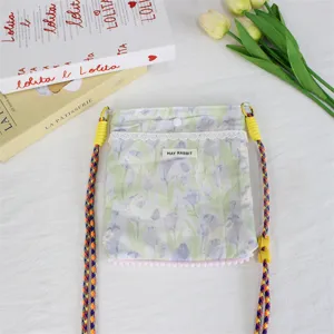 Detailansicht der floralen Segeltuch-Umhängetasche mit feiner Spitze und Trägern.