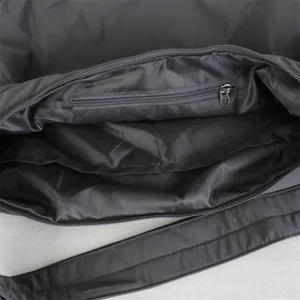 Vista dettagliata dell'interno e della tasca con zip di una borsa a tracolla nera.