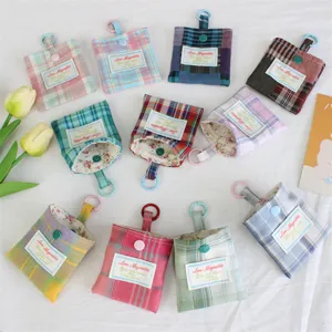 Gedetailleerd overzicht van leuke ruitjes mini portemonnees met ringen voor sleutels en oordop.