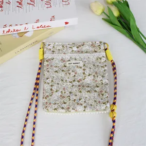 Detailaufnahme der floralen Canvas-Umhängetasche mit bunten Trägern und Spitzenbesatz-Design.