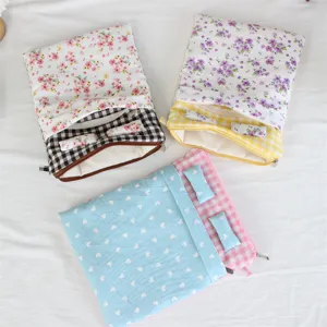 Close-up detail shot of cute bed-shaped quilted tablet sleeve laptop inner bag with mini pillows.