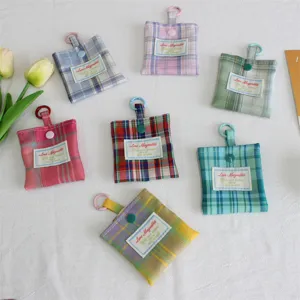 Gedetailleerd overzicht van de ruitjes mini-portemonnee en oortjes tas met hangclip.