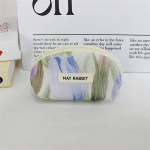 Detailed view of the cute floral cosmetic pouch with smooth zipper and brand label close up.