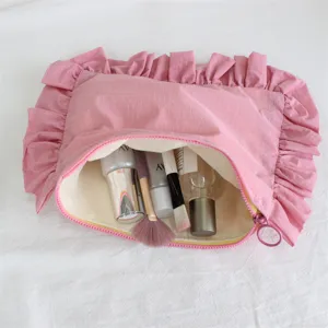 Rosa karierte Kosmetiktasche Nahaufnahme mit Rüschenkante und Reißverschluss Detail.