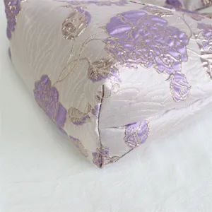 Close-up detail of vintage purple floral jacquard fabric, elegant texture and fine craftsmanship.