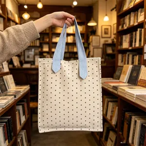Vista dettagliata di una mini borsa in tela con stampa a stelle e manici a righe blu in libreria.