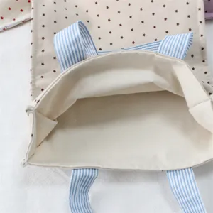Primo piano dell'apertura della borsa tote in tela con stampa di stelle e dettagli interni.