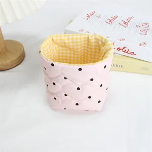 Panier de rangement en tissu matelassé rose motif cœur, détail d'organisateur de bureau.
