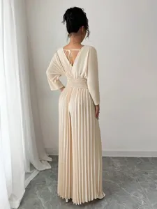 Detail shot of a chic beige pleated V-neck jumpsuit with long sleeves and back tie accent.